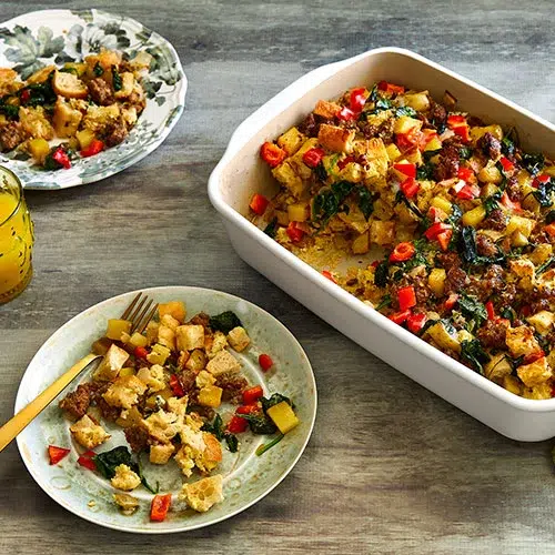 Sausage Strata inside of a rectangular stone baker and one serving on a white plate